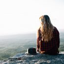 Girl sitting on rocks in the mountain.