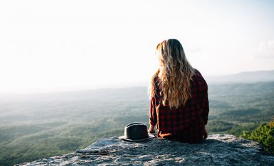 Girl sitting on rocks in the mountain.