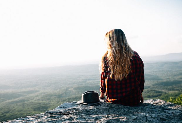 Girl sitting on rocks in the mountain.