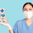 Nurse holding a series of blocks with health symbols.