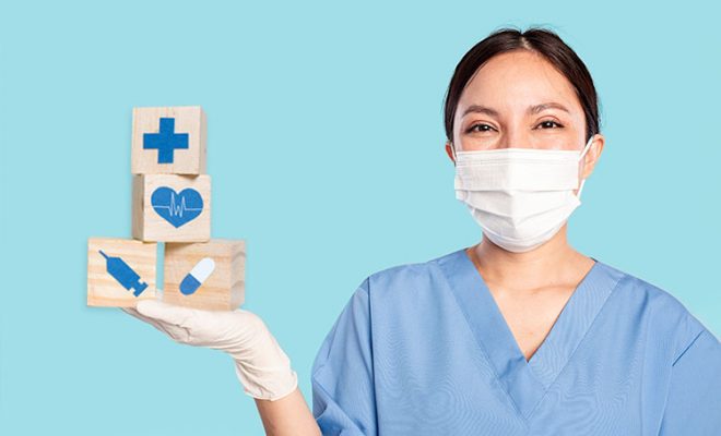 Nurse holding a series of blocks with health symbols.