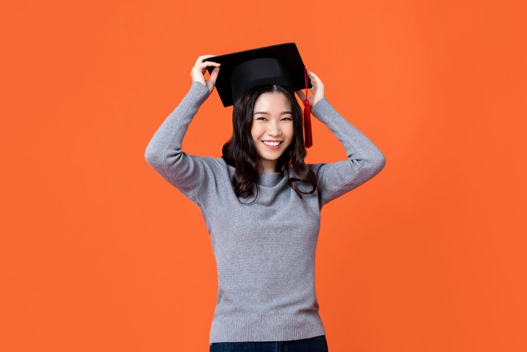 Lady wearing a graduation cap and smiling.