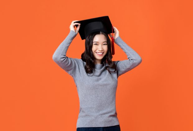Lady wearing a graduation cap and smiling.