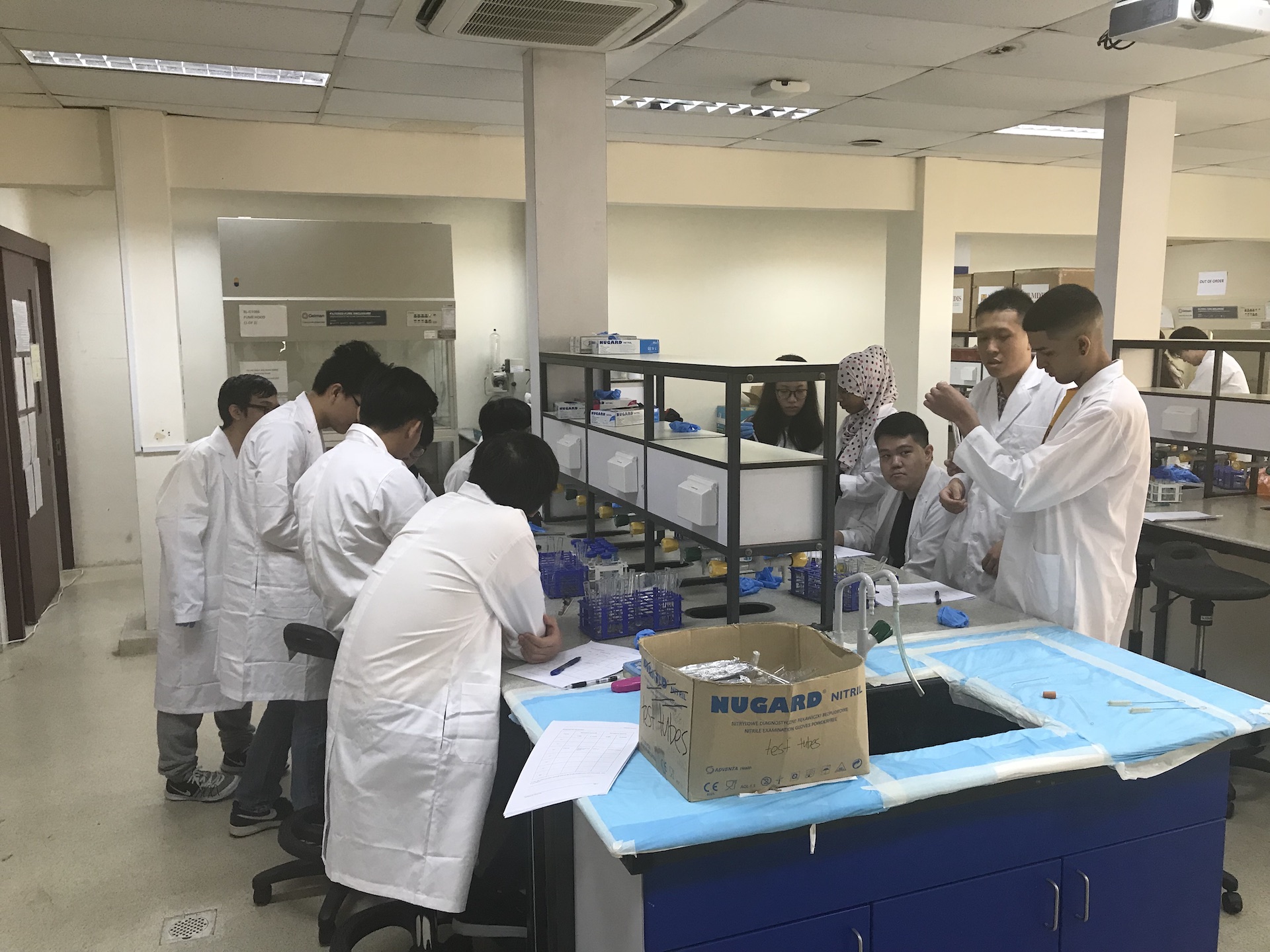 MDIS college students working on a mini experiment in the science lab.