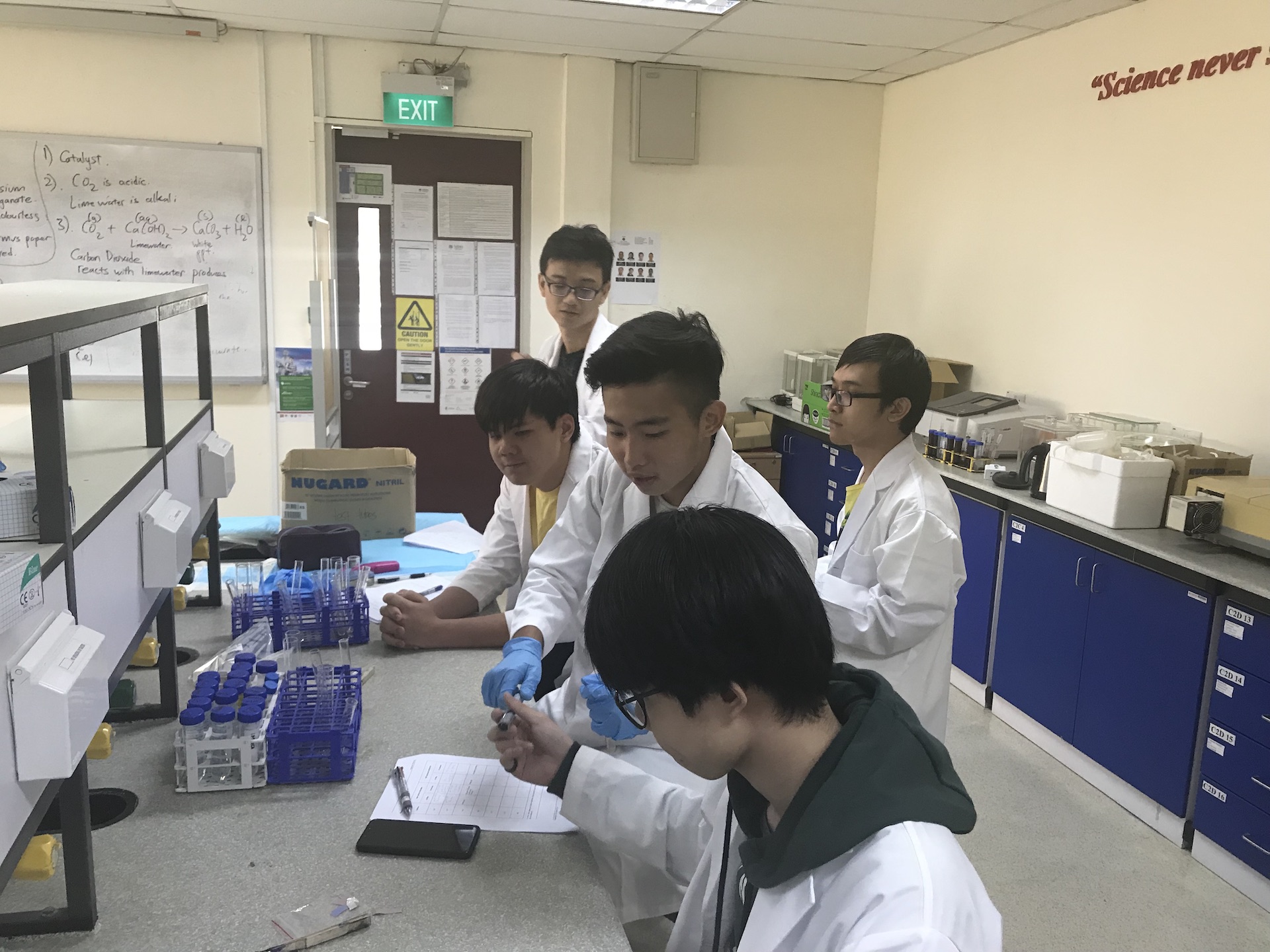 MDIS college students working on a mini experiment in the science lab.