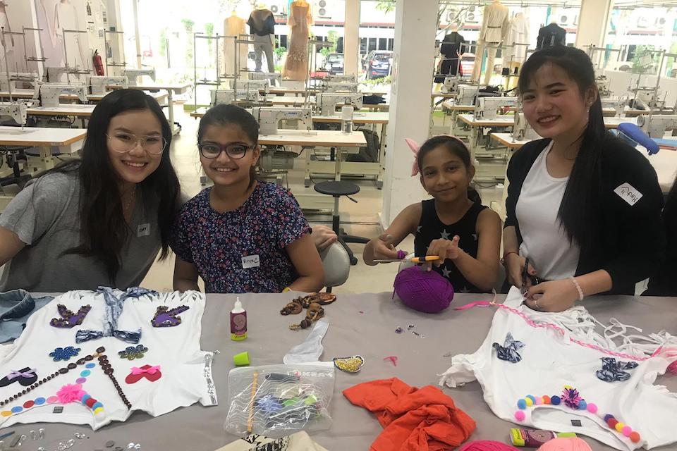 MDIS students posing with children for a picture during a workshop.