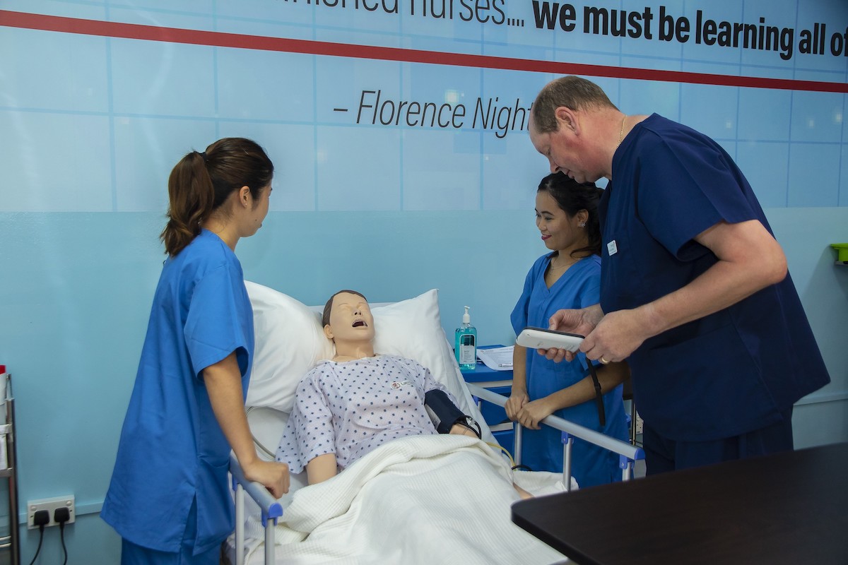 MDIS nursing students observe the condition of a dummy patient.