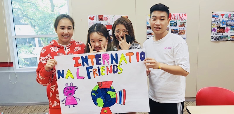 A group of students holding a banner stating 'international friends'.