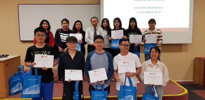 A group of students holding their participation certificates in the lecture theatre.