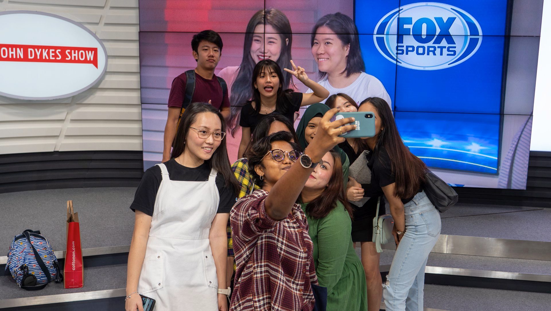 MDIS media students posing for a picture in the broadcasting studio on campus.
