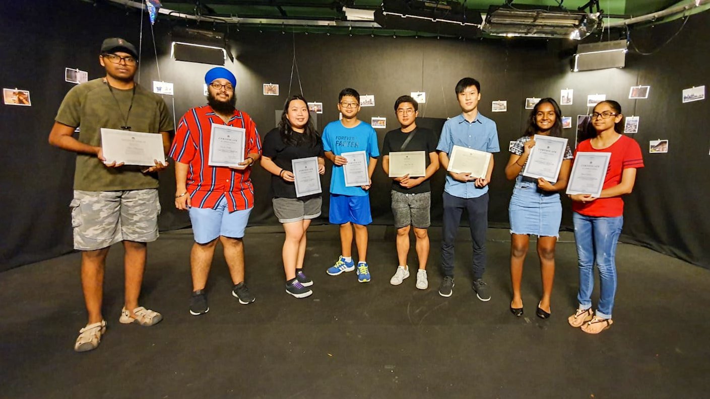 MDIS media students holding their certificate of participation for attending a film ceremony.
