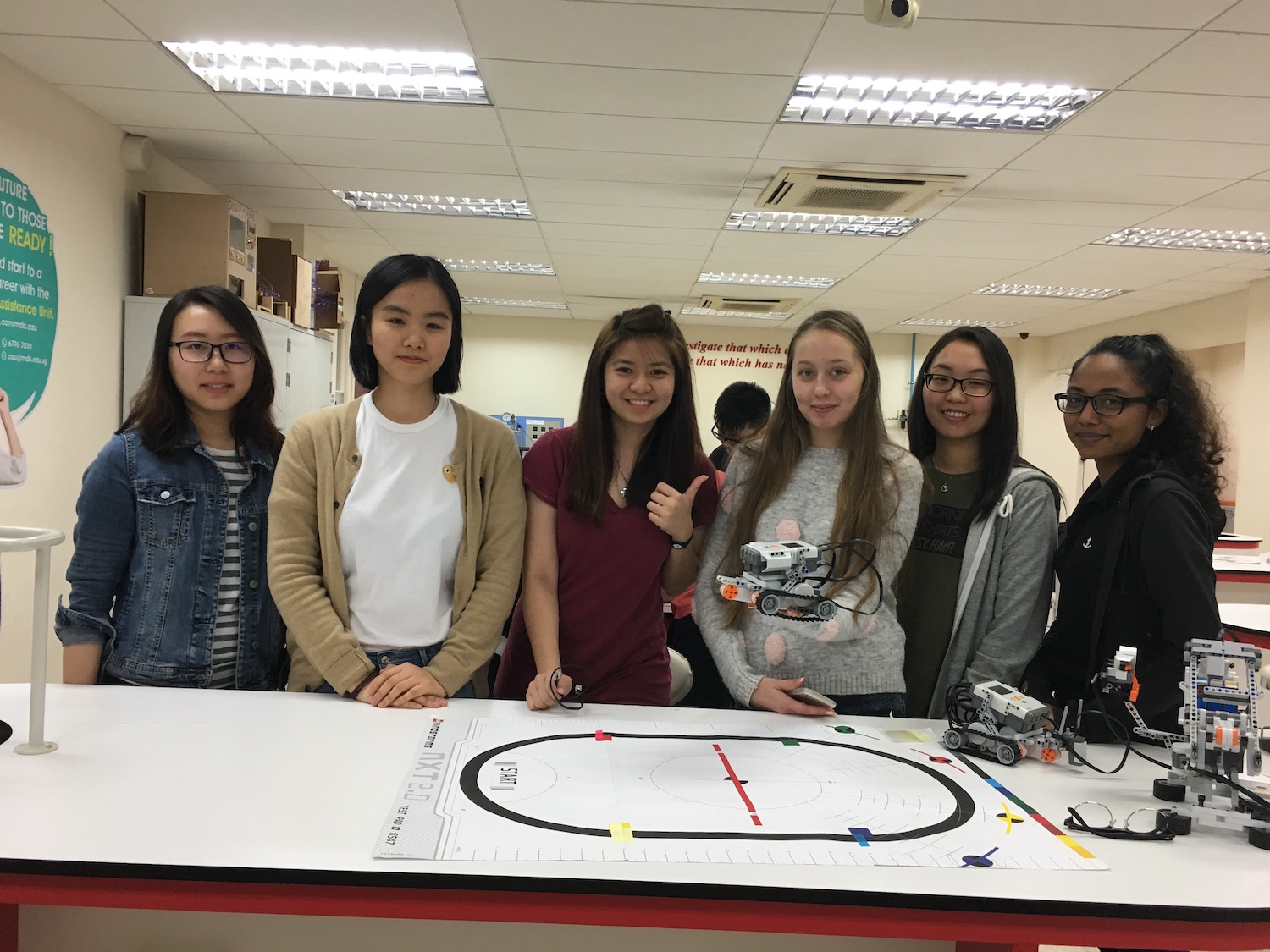 A group of female students posing for a picture in the engineering lab.