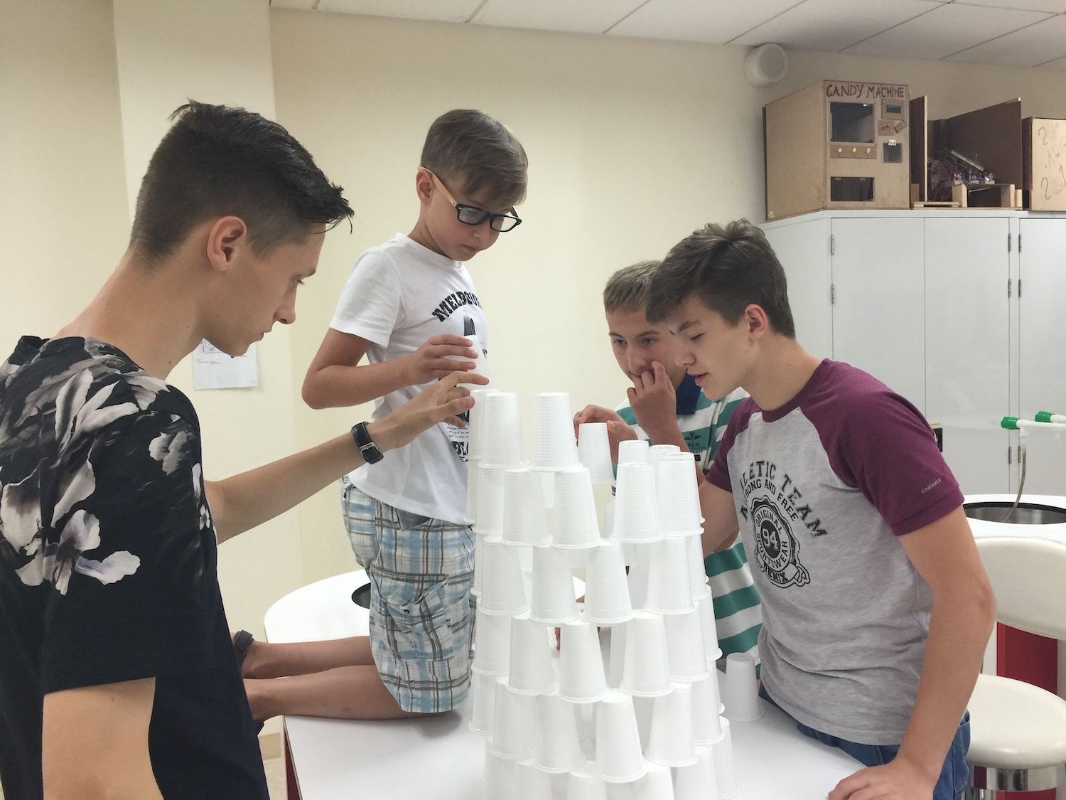 A man and a young buy stacking cups.