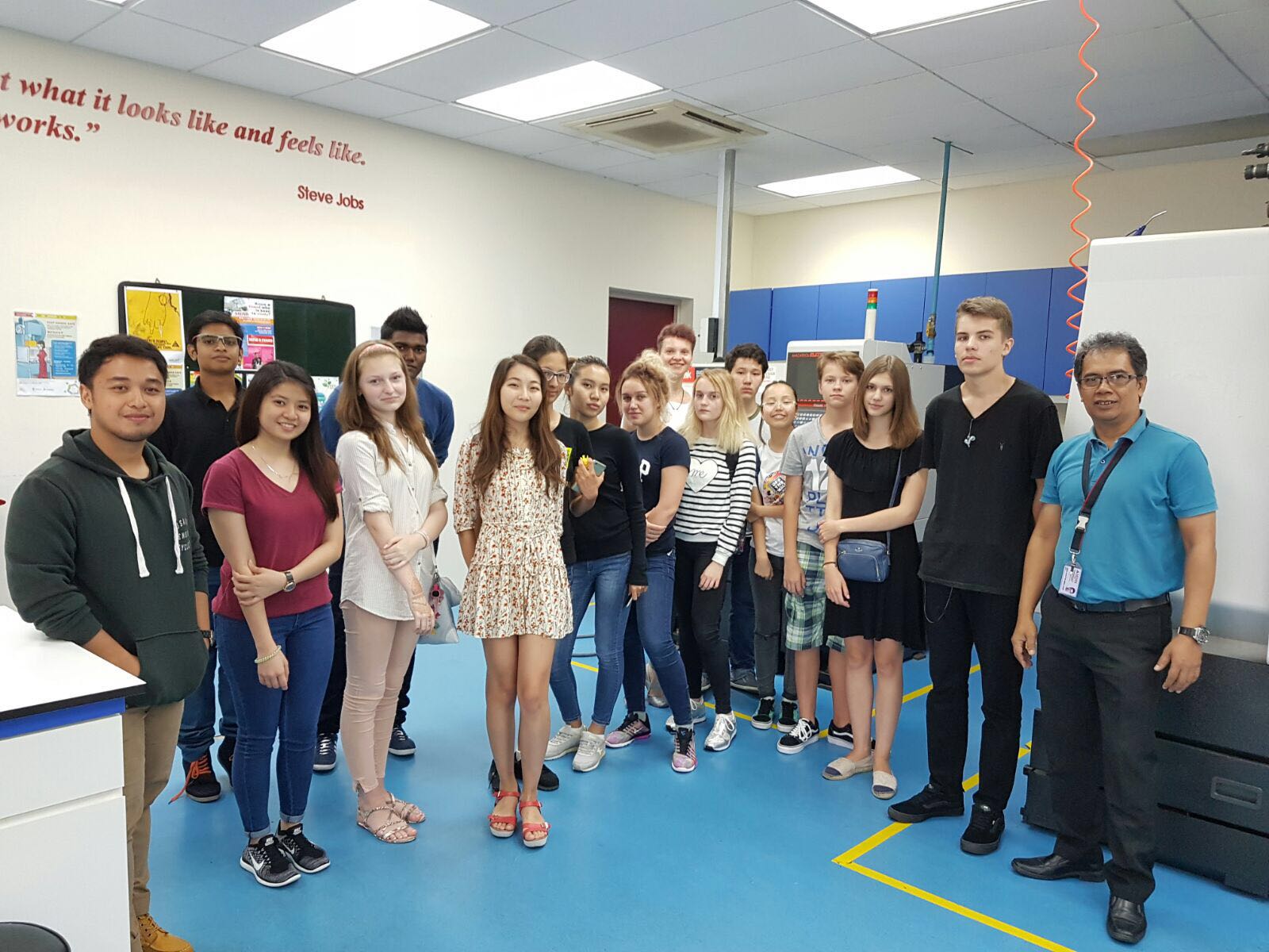 A group of students posing together for a picture in the engineering lab.