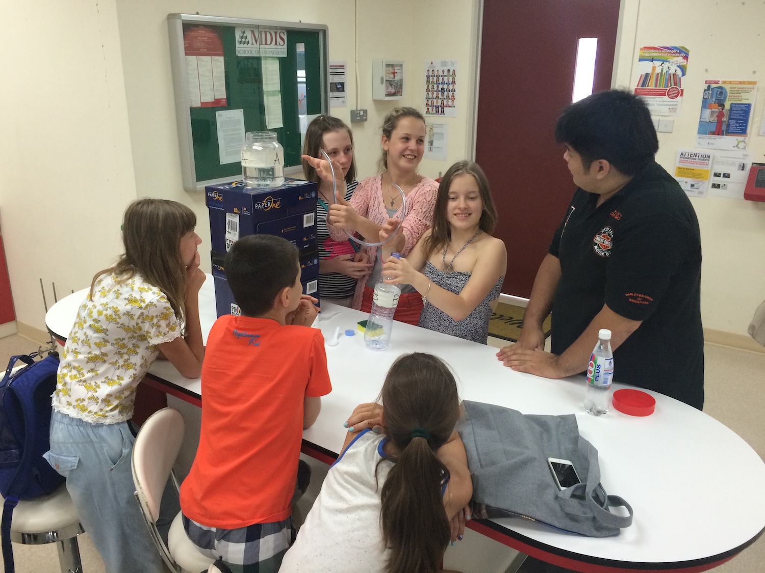 An engineering lecturer guiding his students on a project.