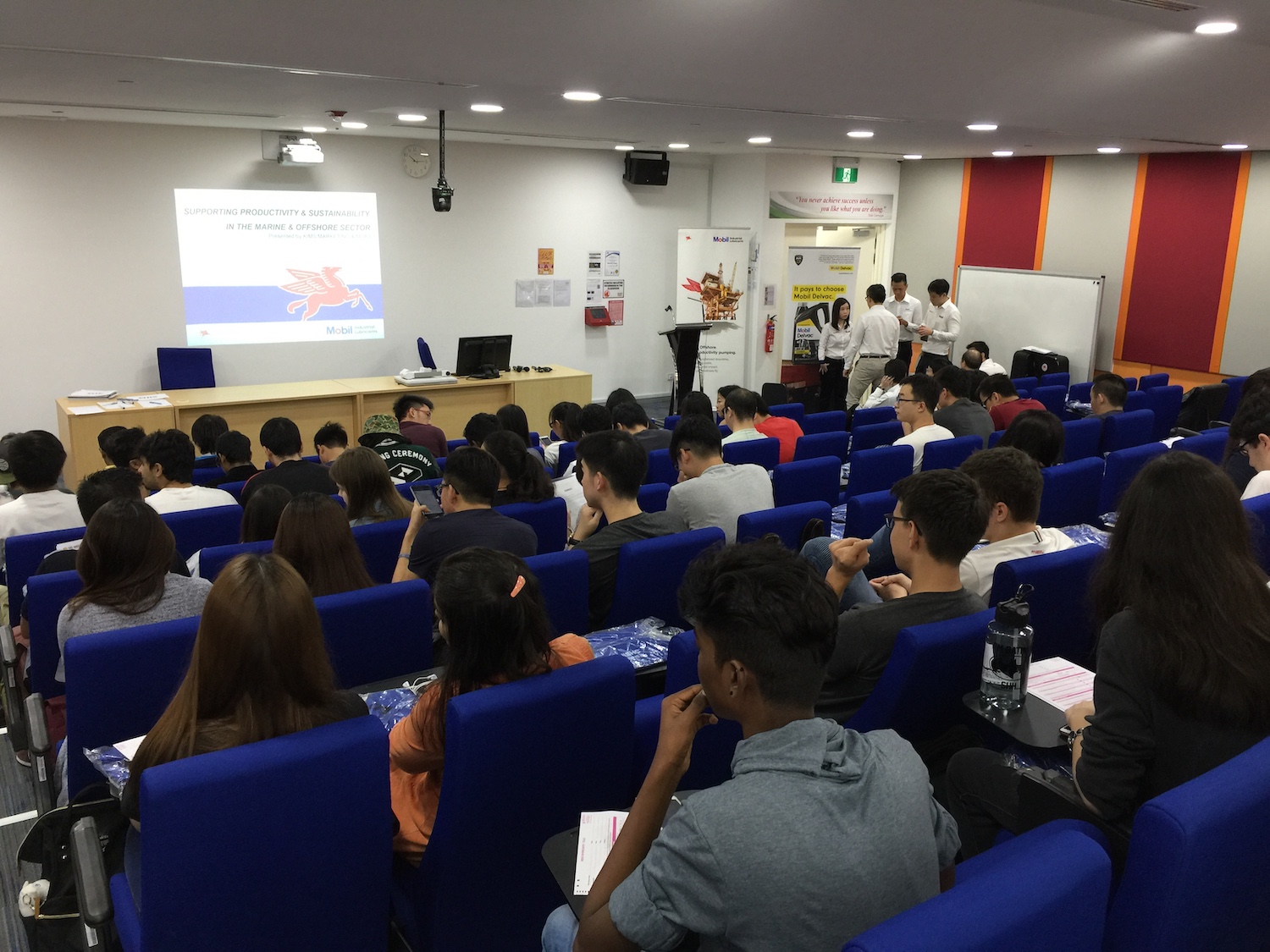 A filled lecture theatre with students waiting for an industry sharing to begin.
