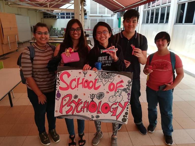 MDIS students posing with a banner of their school.