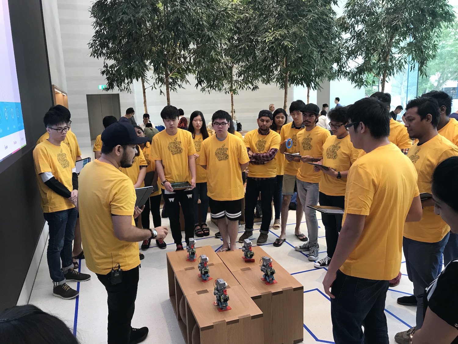 MDIS students listening to an instructor explaining about robotics.