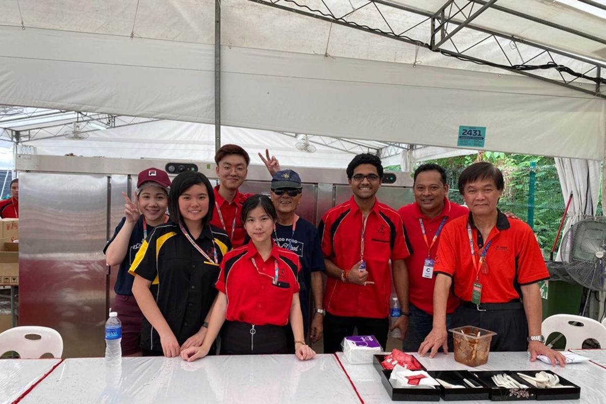 MDIS students posing for a picture at a catering event.